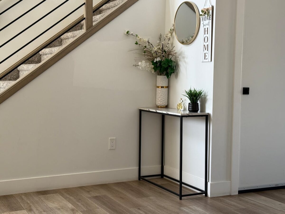 Stylish entryway with minimalist decor, modern staircase, and elegant plants.