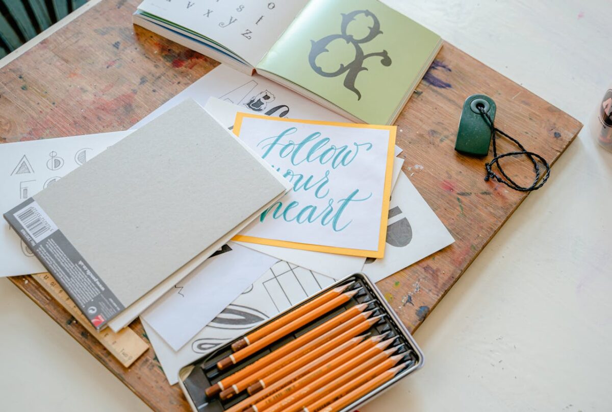 Artistic flat lay of calligraphy tools with inspirational handwritten text, perfect for creatives.